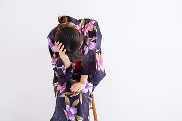 浴衣を着て頭を抱える女性　Japan