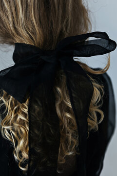 Black bow in woman's hair
