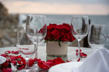 Cena romántica al atardecer con rosas y copas