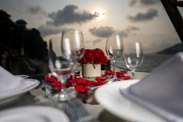 Cena romántica copas y rosas a la orilla del mar