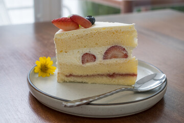 Strawberry shortcake with dish on wooden table. 