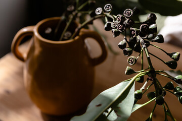 Foraged foliage in a black vessel vase