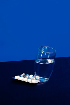 Pills under a glass of water