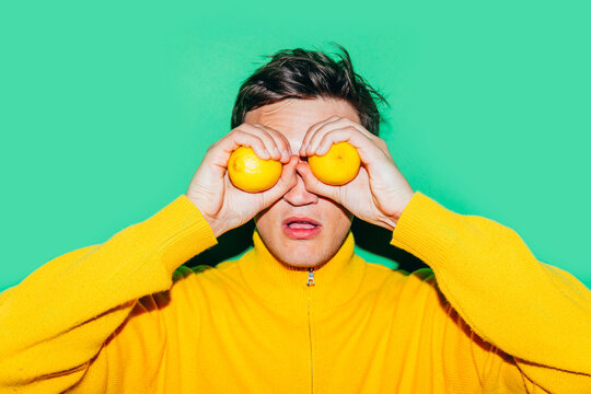 Man in Yellow Holding Lemons