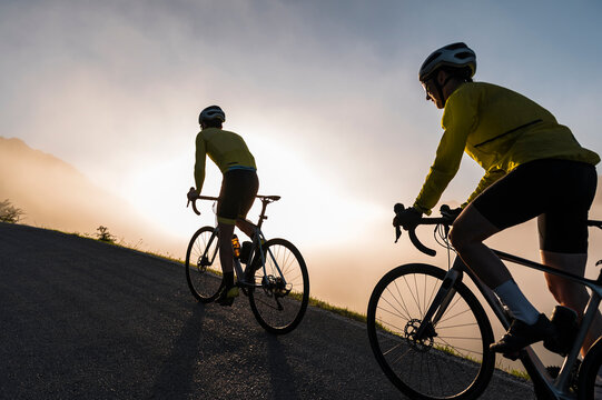 Man and woman cycling together on misty morning
