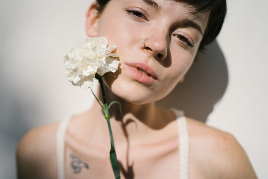 Sensual female with flower near chest
