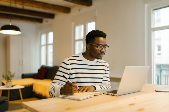 Young man studying with computer at home