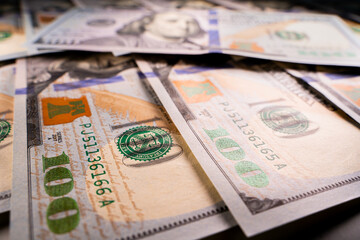 Close-up beautiful clean new one hundred dollar bill lies on other one hundred dollar bills