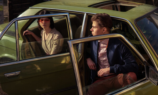 A stylish couple inside a car