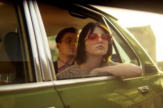 A stylish couple inside a car