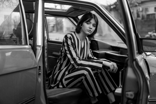 Stylish Woman sitting in the old car