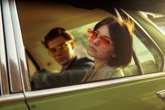 A stylish couple inside a car