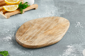 Food mockup. Empty wooden board on concrete table with cooking  ingredients. Wooden board  with...