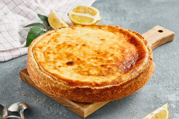 Sweet bakery - cottage cheese pie on gray stone background. Baked cheesecake in rustic style on stone table. Aesthetic composition with cottage pie. Cottage cheese  tart.
