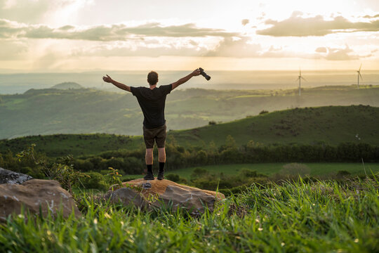 Man on a rock in the middle of the mountain.