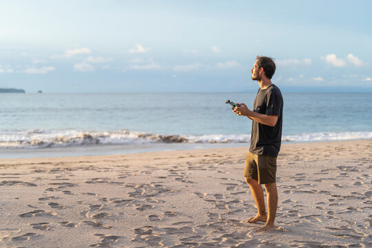 Man with a drone controller in his hands on the beach.