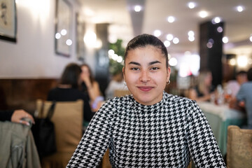 young woman with oriental features sitting in a restaurant