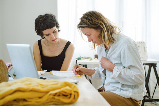 Two women discussing dress design