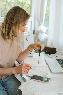A tailor calculates fabric costs at her working place
