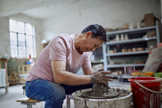 East Asian Small Business Owner Creates Pottery In His Workshop