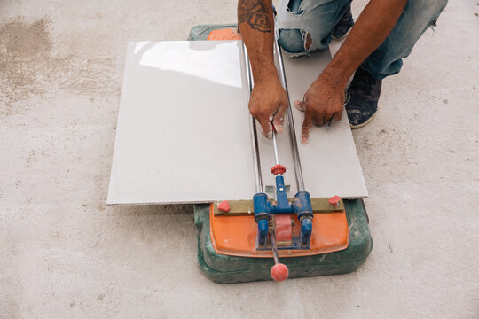 Close op of a man cutting porcelain tile