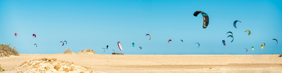 Many kitesurfers on the beach skyline are getting ready to practice Kitesurfing on the Corralejo...