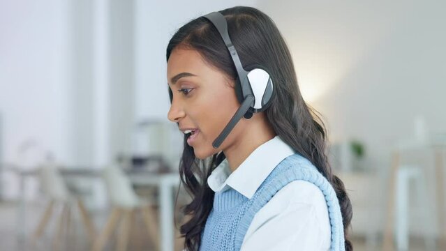 Friendly call center agent using a headset while consulting for customer service and sales support. Confident and happy young business woman smiling while operating a helpdesk and talking to clients