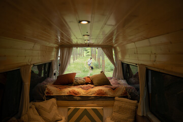 Indoor view of cute camper van in the forest with man and dog