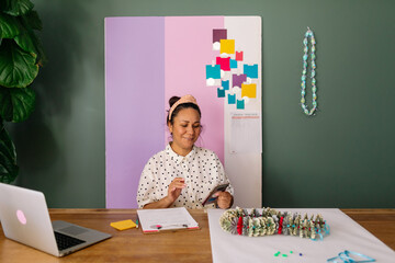 Money lei maker using smartphone in studio