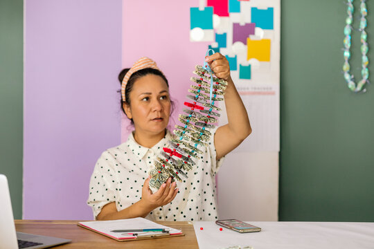 Crafter woman holding money lei in studio