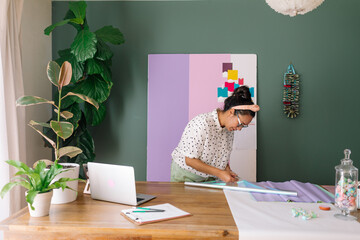 Latina cutting iridescent wrap at work