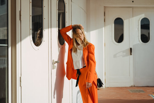 Fashionable woman in orange clothes in the city