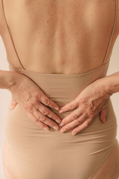 Crop senior woman with underwear from back