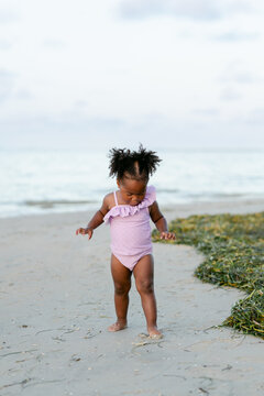 Girl digs toe into sand