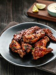 Roasted chicken wings with spices. Served with sauce