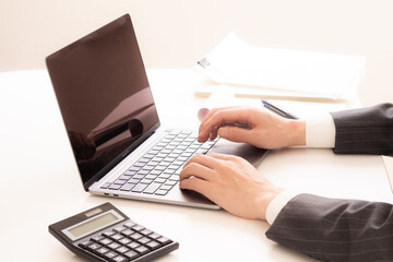 パソコンで仕事をしているビジネスマン／手元／スーツ