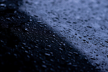 black car surface where raindrops stick It's a beautiful water drop, taken close-up.