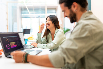 Two happy colleagues working in a coworking space