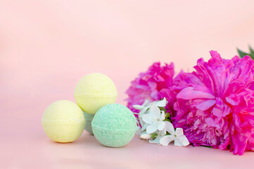 Obraz na płótnie Canvas SPA composition with bath bombs and two peonies on a pink background. Close-up. Copy the space for the text. The concept of therapy. I'm taking a relaxing bath.Homemade spa products