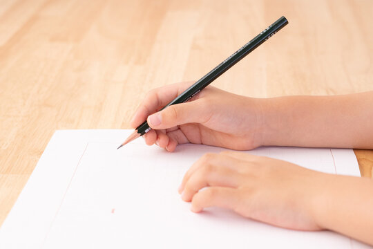 原稿用紙と子どもの手元／読書感想文を書く子ども／横から