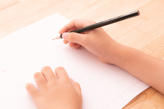 原稿用紙と子どもの手元／読書感想文を書く子ども／後ろから