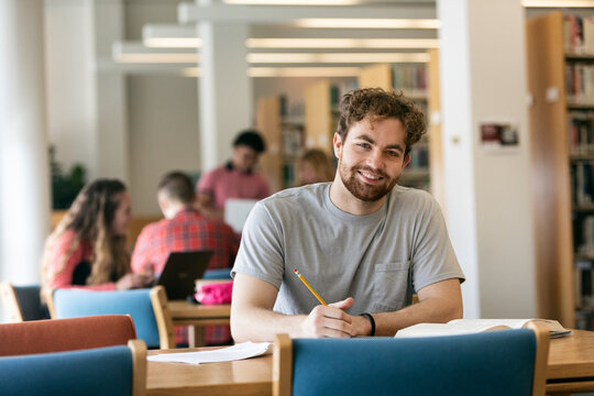 Confident And Smiling College Student In Library