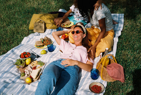 Multiethnic lesbian couple with their daughter enjoying picnic