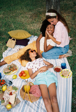 Multiethnic lesbian couple with their daughter enjoying picnic