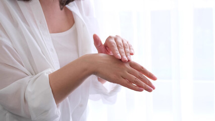 lady runs gently over her hand, enjoying the softness of the skin after using the cream. the concept of self-care, self-love.