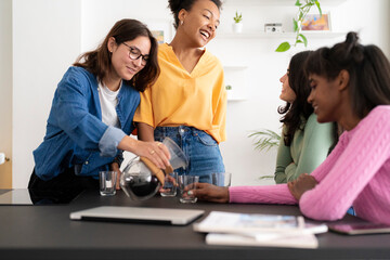 Happy diverse designers having coffee break in studio