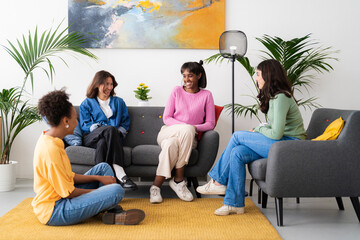Diverse women speaking on sofas in room