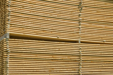 Lots of planks stacked on top of each other in the warehouse. Lumber for further use in construction. Pile of sawn boards