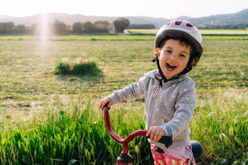 Little girl riding a bicycle in nature 