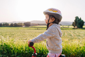 Little girl riding a bicycle in nature 